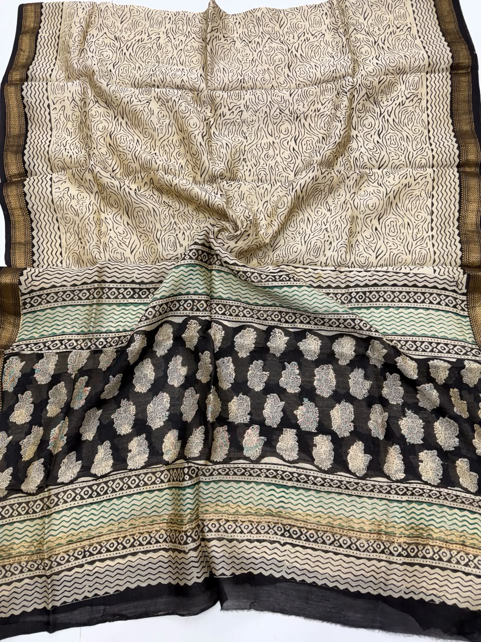 Detailed view of the natural black handloom Maheshwari silk dupatta, highlighting the intricate wavy patterns, block prints, and the elegant handloom woven golden Zari border.