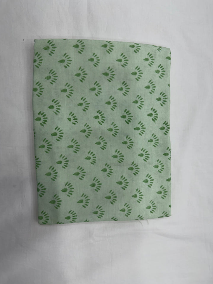 A folded length of solid light green cotton Santoon silk fabric with a smooth finish, shown against a clean white background.
