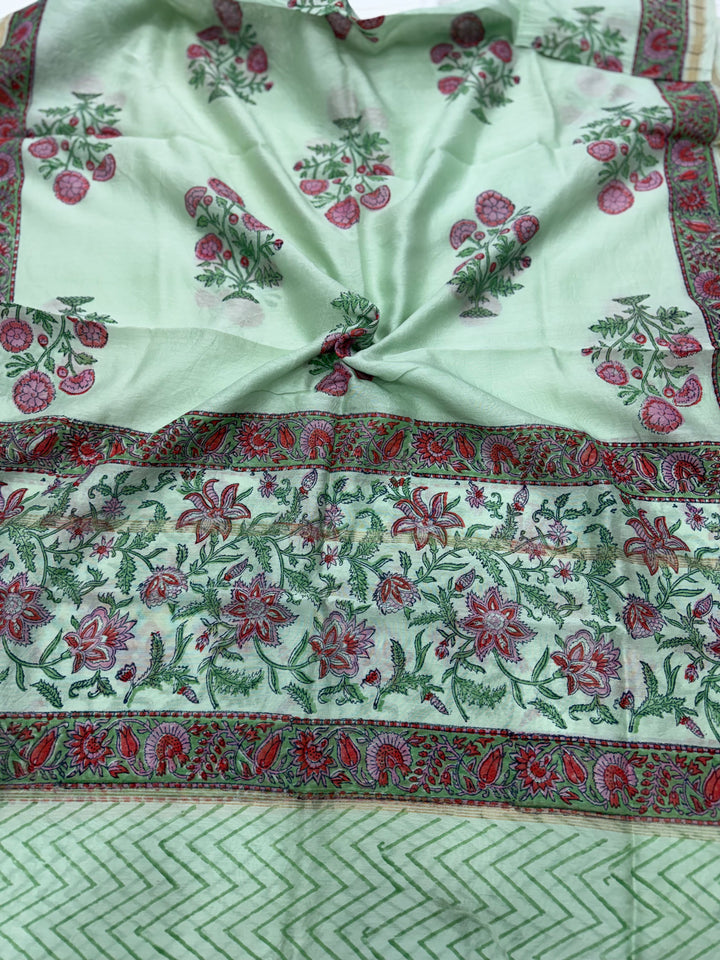 A mint green Chanderi silk dupatta featuring delicate pink and green floral block print motifs, highlighted by a wide patterned border with traditional ethnic designs.