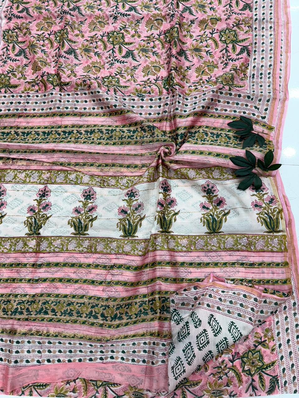 A premium Chanderi silk saree featuring delicate Sanganeri hand block floral prints and a traditional shimmering zari border.