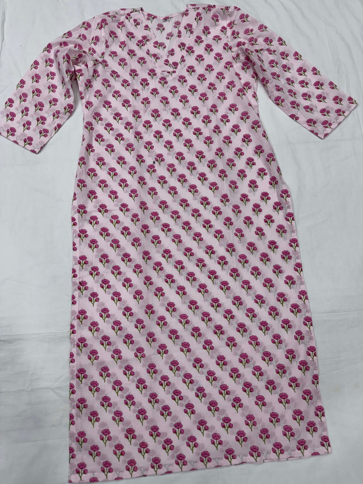 Close-up shot of a baby pink cotton kurta showing the elegant V-neckline and intricate pink floral block print details.