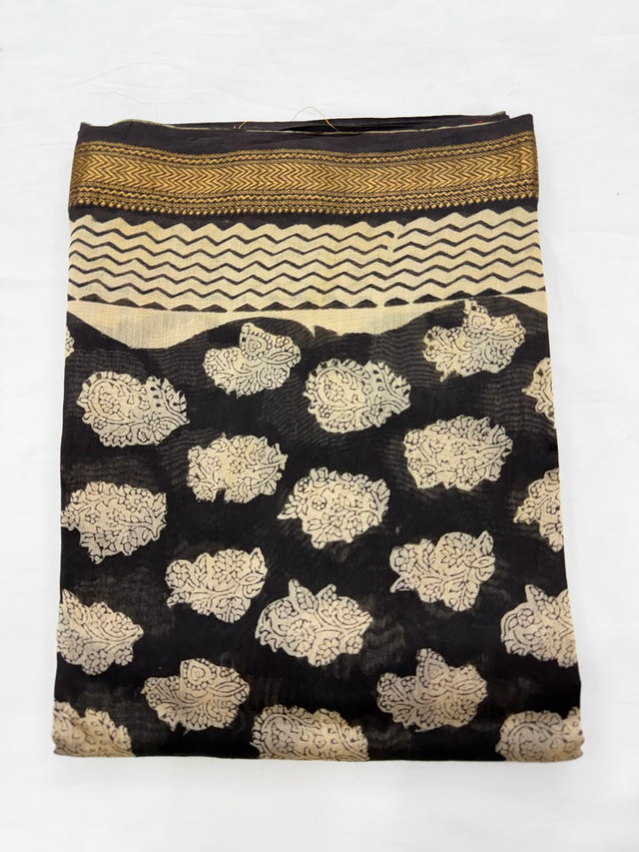 Close-up of the unstitched natural black Maheshwari silk kurta fabric, featuring traditional Bagru hand block printed buti floral motifs in a golden-beige hue.