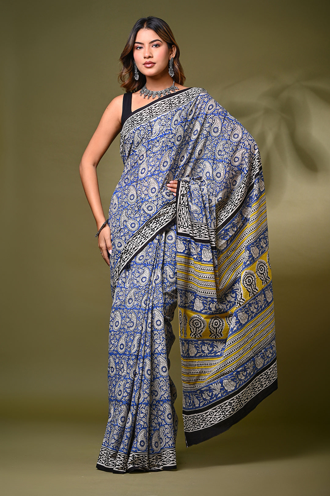 ront view of a model in an authentic Bagru handblock print mulmul cotton saree, showcasing intricate paisley (kairi) motifs in traditional blue and off-white natural dyes with a vibrant yellow patterned border.