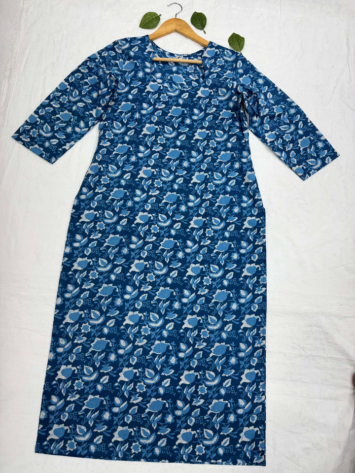 Natural indigo blue dye se bana Bagru hand block print floral cotton kurta, jo white background par fold karke display kiya gaya hai.