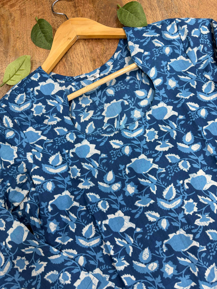 Natural indigo blue dye se bana Bagru hand block print floral cotton kurta, jo white background par fold karke display kiya gaya hai.