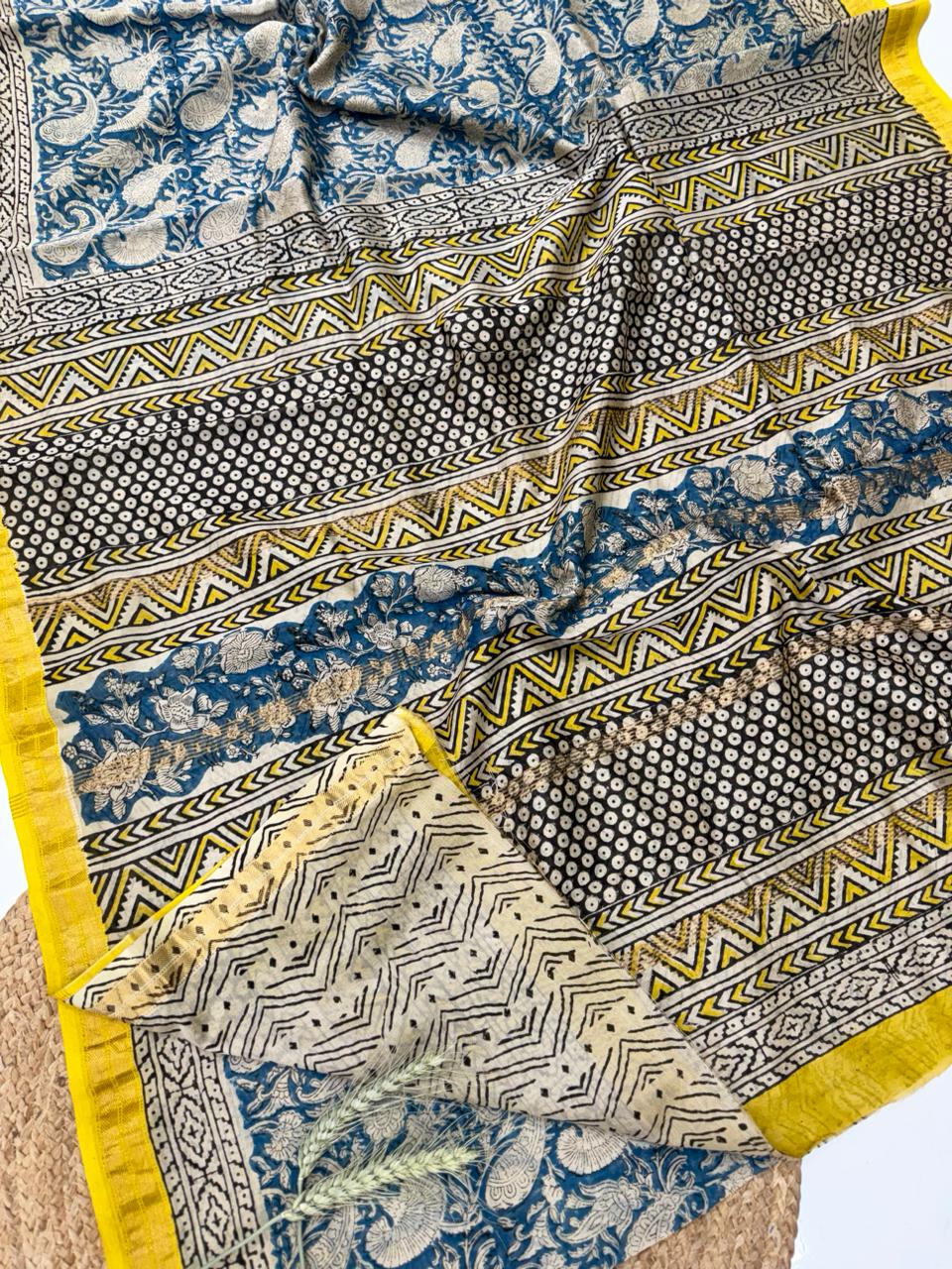 "Handcrafted Maheshwari silk saree featuring traditional Bagru hand-block prints blue, cream, and black patterns. The saree showcases intricate geometric and floral motifs with a distinctive yellow and gold zari border."