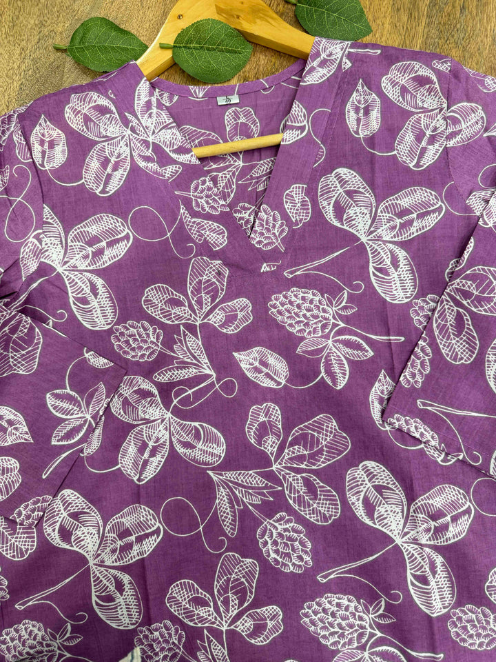 Purple background par safed rang ke pine-cone aur floral motifs waala Bagru hand block print cotton kurta, white cloth background par displayed