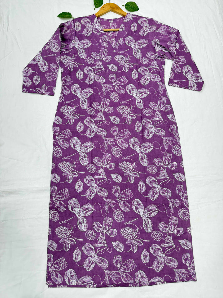 Purple background par safed rang ke pine-cone aur floral motifs waala Bagru hand block print cotton kurta, white cloth background par displayed.