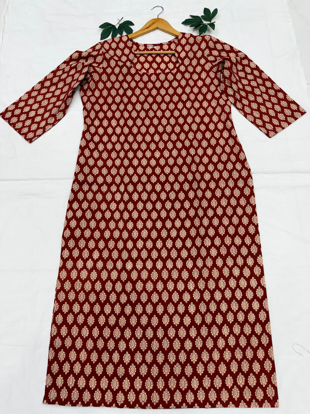 Rust aur gud jaggery tones me authentic Bagru hand block print cotton kurta ek safed background par neetly fold kiya hua hai.