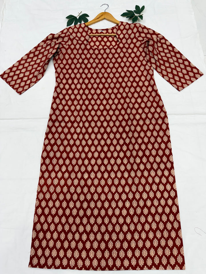 Rust aur gud jaggery tones me authentic Bagru hand block print cotton kurta ek safed background par neetly fold kiya hua hai.