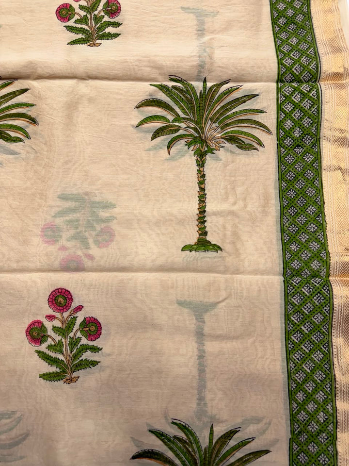 Close-up of the unstitched beige Maheshwari silk kurta fabric, showcasing beautiful pink and green hand block printed floral bootis and a geometric woven border.