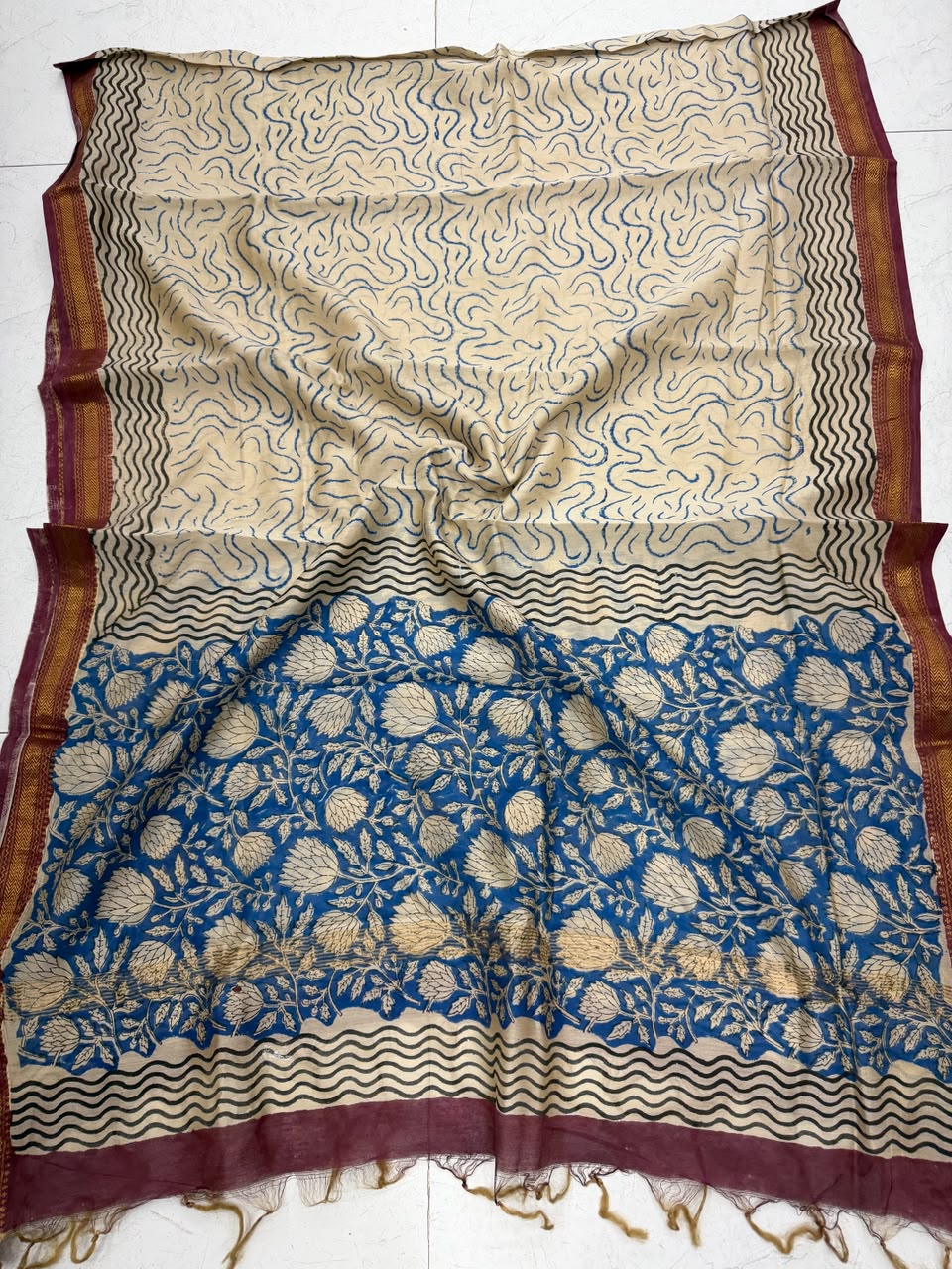 Detailed view of the beige and blue handloom Maheshwari silk dupatta, highlighting the traditional wavy block prints, geometric accents, and a contrasting rich maroon handloom woven golden Zari border.