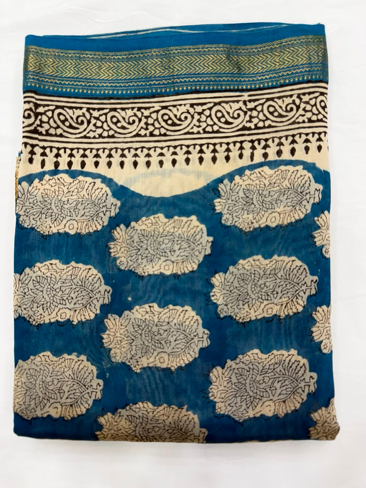Close-up of the unstitched deep blue Maheshwari silk kurta fabric, showcasing the traditional all-over beige floral coin and leaf motifs hand-stamped by the master artisans of Bagru.