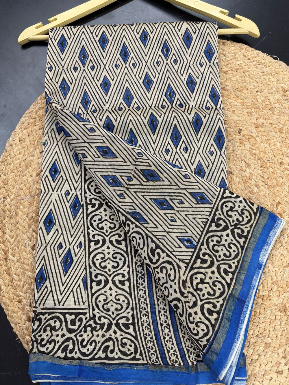 Close-up of a white and blue Chanderi Silk saree featuring intricate geometric diamond block prints on the body and a traditional gold-accented floral border.