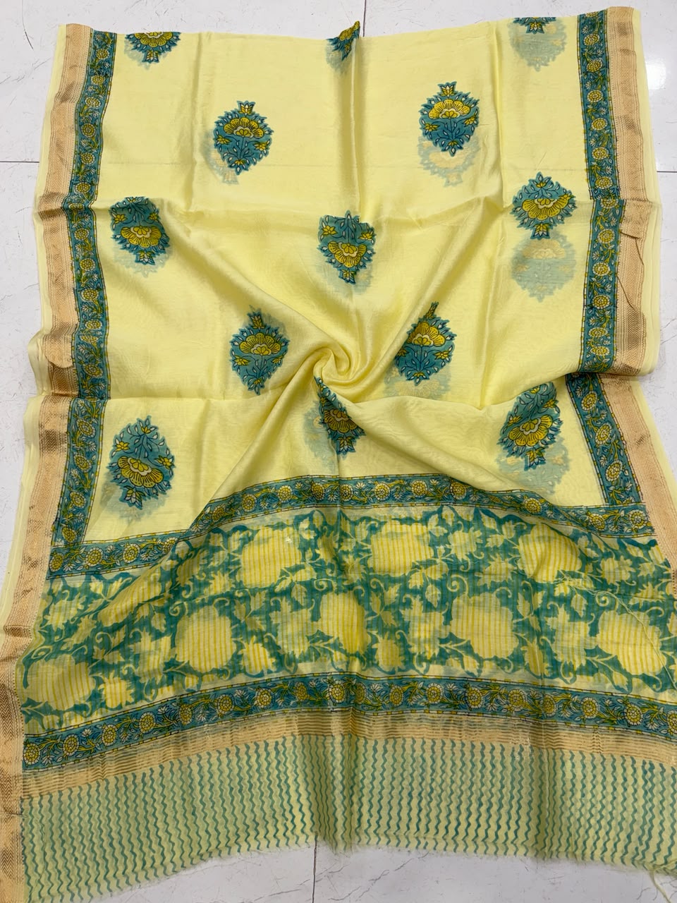 Detailed view of the bright yellow handloom Maheshwari silk dupatta, highlighting the intricate green floral borders, wavy block-printed patterns, and a premium handloom woven golden Zari border.