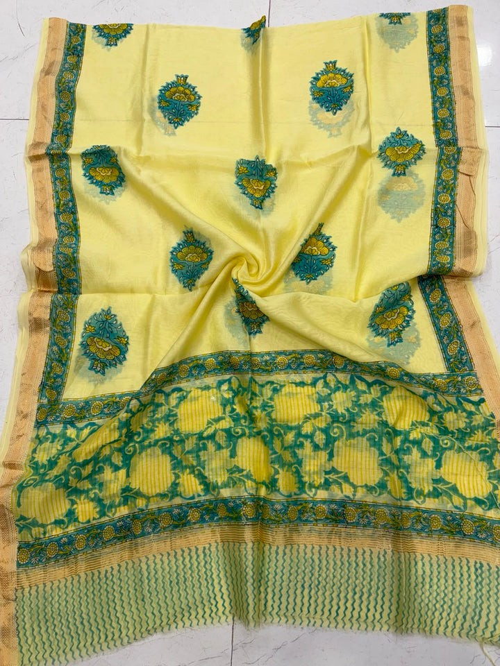 Detailed view of the bright yellow handloom Maheshwari silk dupatta, highlighting the intricate green floral borders, wavy block-printed patterns, and a premium handloom woven golden Zari border.