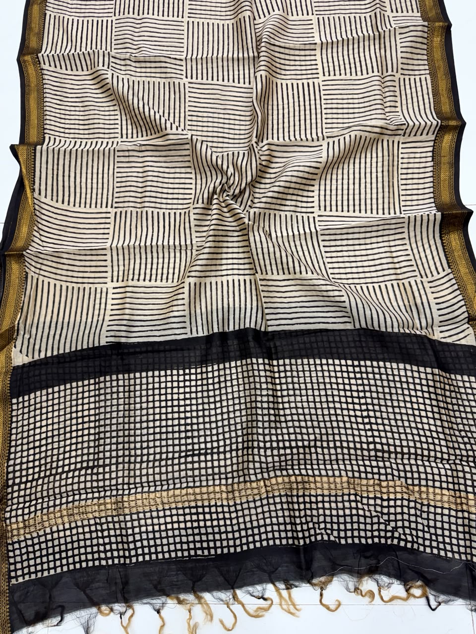 Detailed view of the cream and black handloom Maheshwari silk dupatta, showcasing the intricate geometric borders, crisp check patterns, and a premium handloom woven golden Zari border.