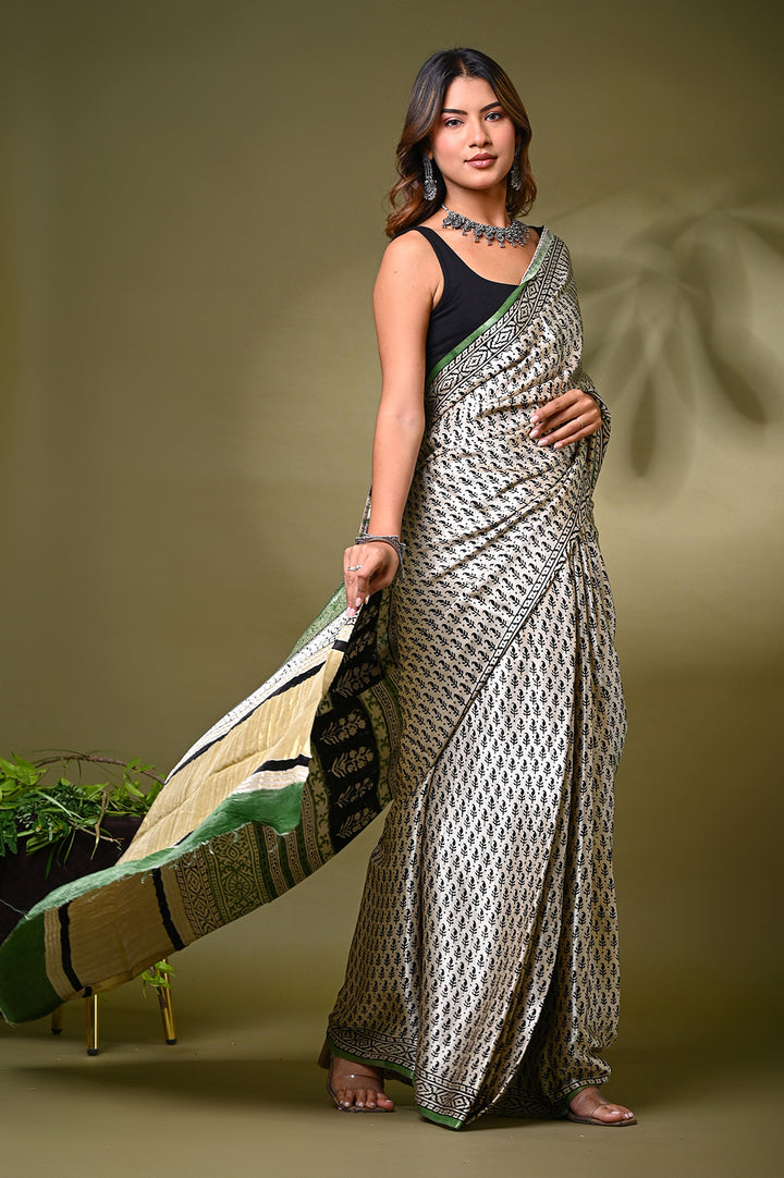 An authentic eco-friendly plant-based dyed cream Modal Silk saree with an all-over small floral dot pattern and a traditional patterned border.