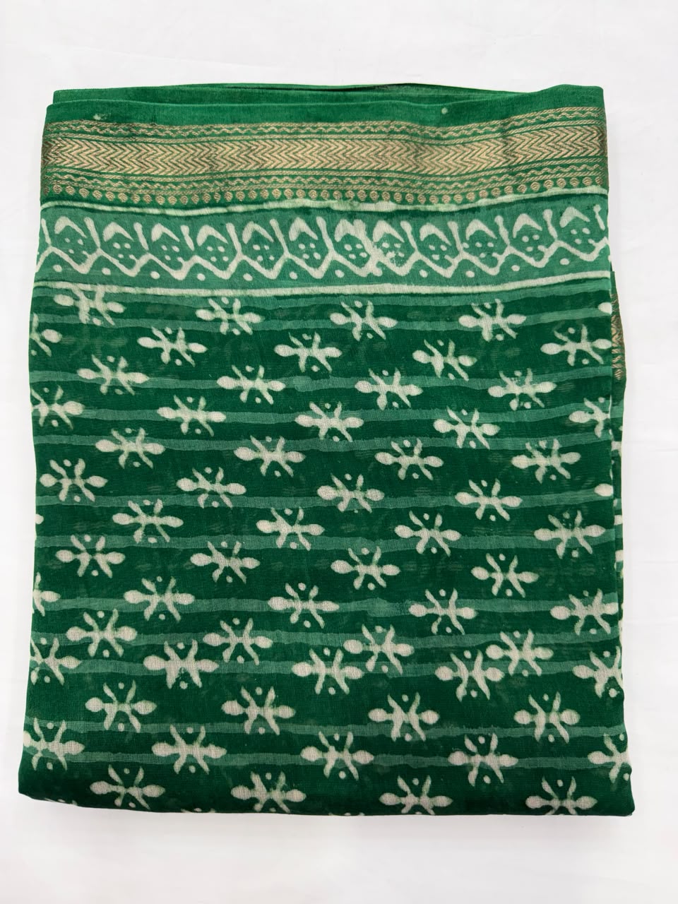 Close-up of the unstitched green Maheshwari silk kurta fabric, highlighting the traditional mud-resist Dabu hand block printed white geometric and floral patterns.