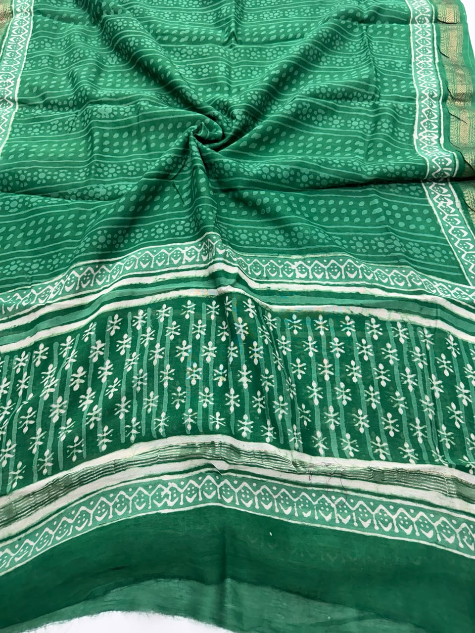Detailed view of the pure green Maheshwari silk dupatta, highlighting the intricate Dabu block prints, unique resist textures, and the elegant handloom woven golden Zari border.