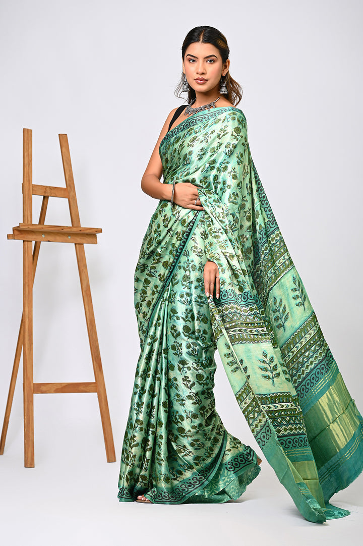An authentic herbal-dyed green Modal Silk saree with a repeating geometric block print design and a classic running border, styled against a plain white background.