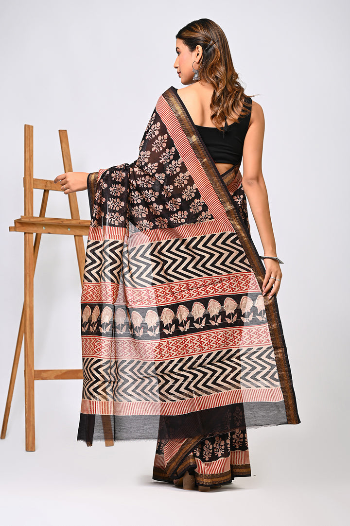 A woman from the back showing the drape of a natural mustard yellow Maheshwari silk saree featuring a delicate Gud Buti jaggery dot pattern and a traditional patterned border.