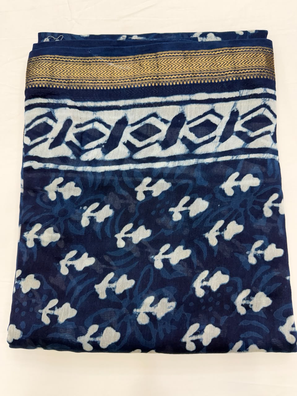 Close-up of the unstitched indigo blue Maheshwari silk kurta fabric, featuring traditional mud-resist Dabu hand block printed small scattered floral buti motifs.