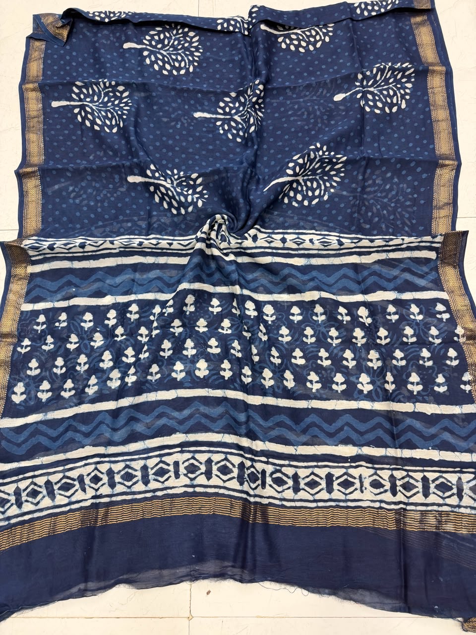 Detailed view of the deep indigo handloom Maheshwari silk dupatta, highlighting the intricate Dabu block prints, elegant patterns, and a rich handloom woven golden Zari border.