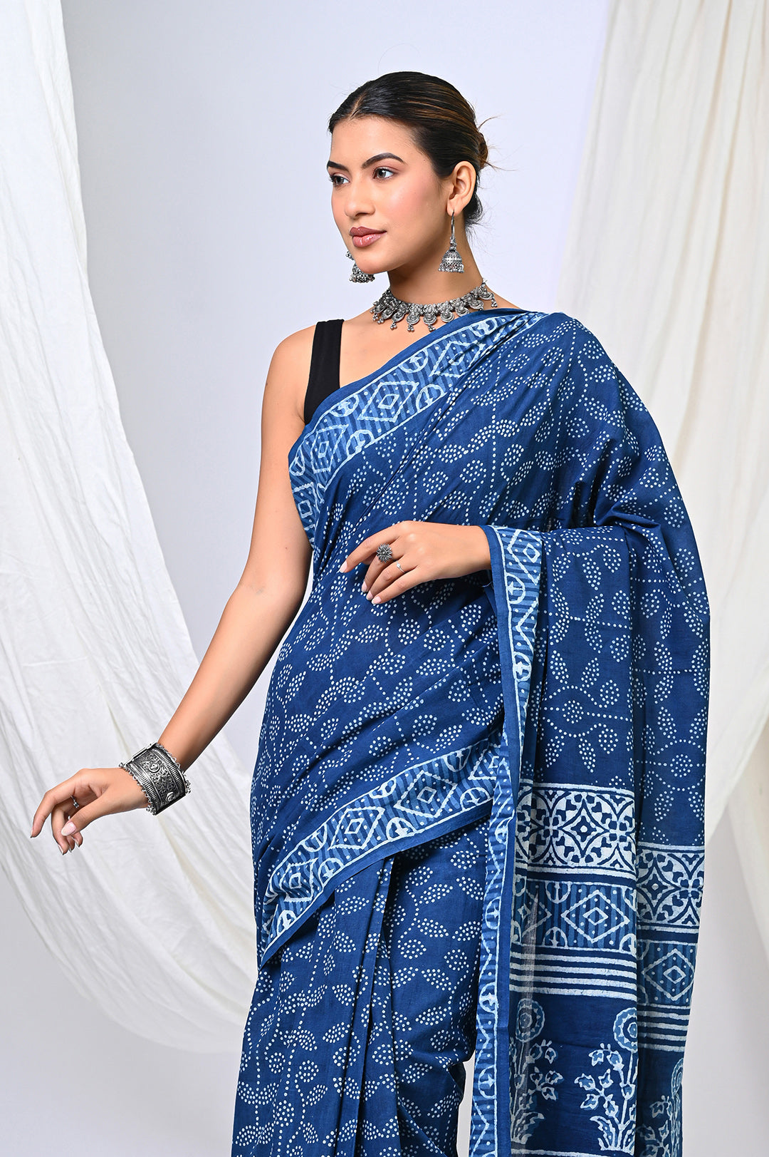 Pure natural indigo blue Dabu handblock print mulmul cotton saree showing a side-angle view of the all-over geometric dot print and detailed designer block-printed pallu patterns.