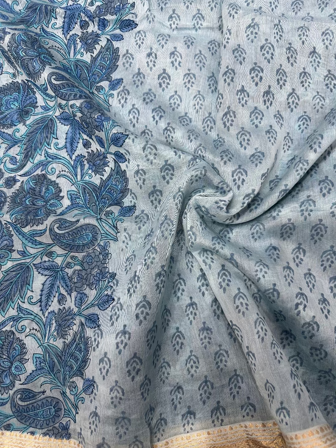 Model wearing a light blue Sanganeri hand-block floral print Maheshwari silk-cotton saree with a classic gold zari border and matching unstitched blouse piece.