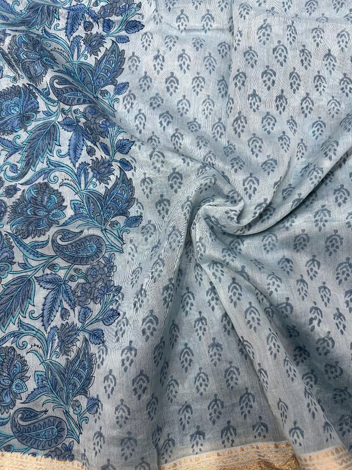 Model wearing a light blue Sanganeri hand-block floral print Maheshwari silk-cotton saree with a classic gold zari border and matching unstitched blouse piece.