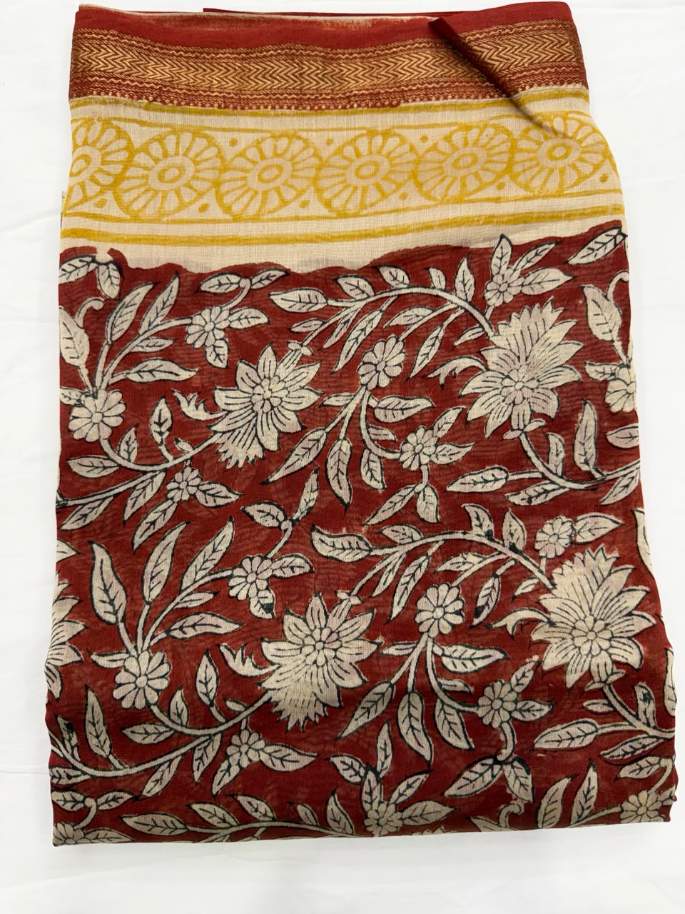 Close-up of the unstitched deep maroon Maheshwari silk kurta fabric, highlighting the elegant all-over cream and gold traditional Bagru hand block printed floral jaal motifs.