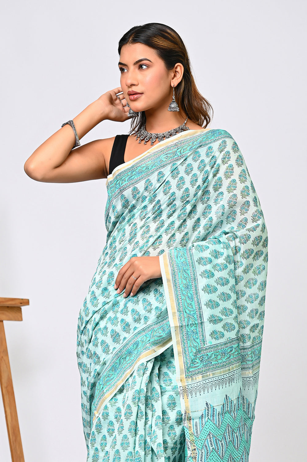 Full-length studio view of a serene light green pure Chanderi silk saree showcasing its natural golden sheen, fine hand-stamped blocks, and an elegant matching pallu.