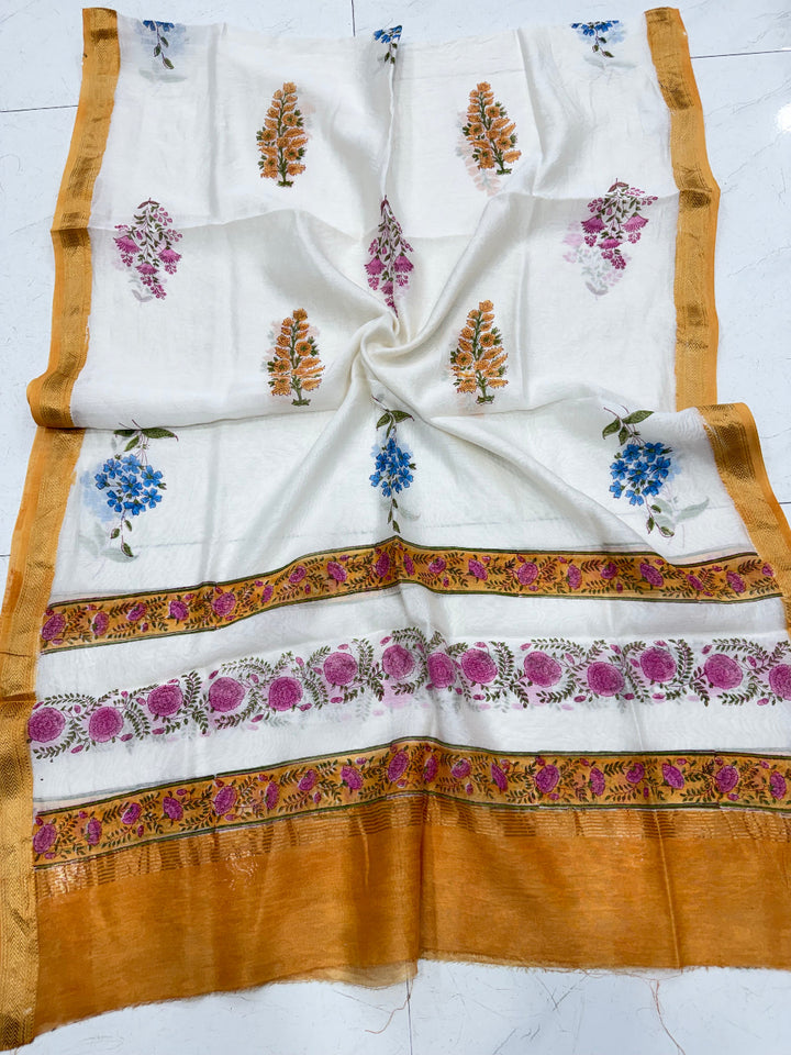 Detailed shot of the pure Maheshwari silk dupatta showing the intricate floral block prints and the rich golden-yellow Zari border weave.