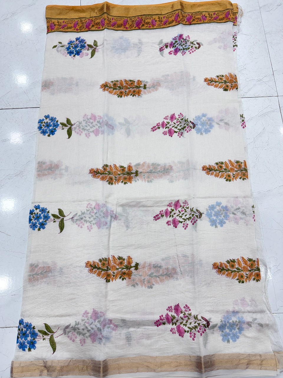 Close-up of the unstitched Maheshwari silk kurta fabric in cream, adorned with detailed Mughal-inspired multicolored floral multi buta hand block prints.