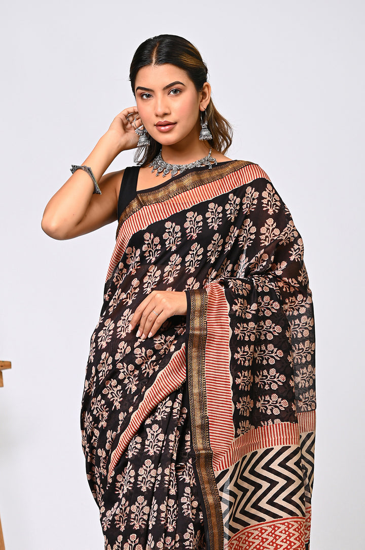 Full-length view of a black Maheshwari silk saree handcrafted by Bagru Hastkala Printers using natural iron mud dye, detailed with traditional rust floral prints and a patterned pallu.