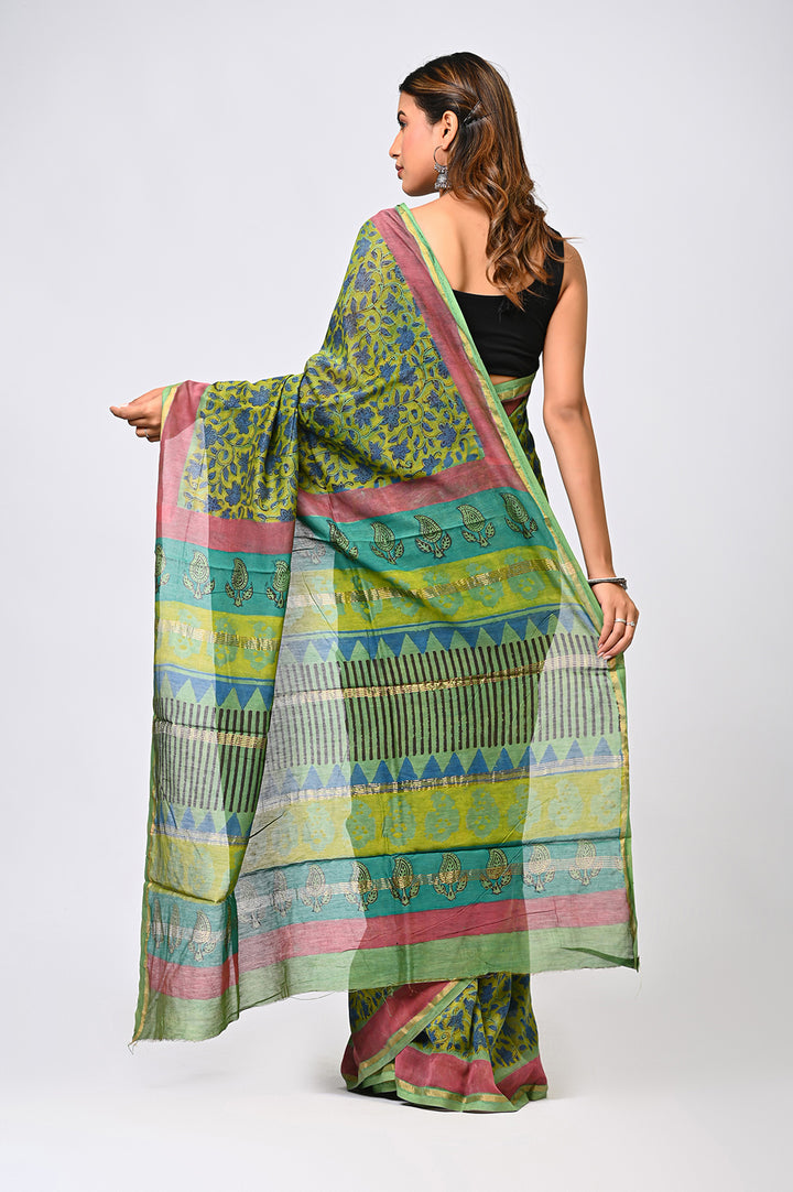 A woman in profile demonstrating the sheer, lightweight drape of an authentic plant-based green Chanderi silk saree featuring traditional hand block printed motifs by Bagru Hastkala Printers.