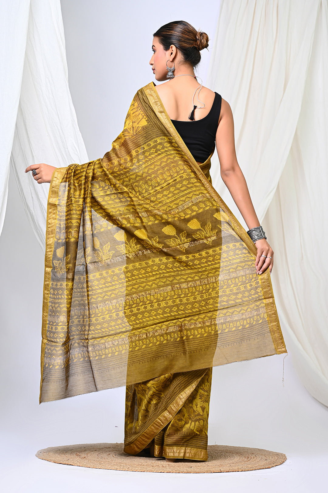 Full-length view of an authentic Maheshwari silk saree in a warm golden mustard color, handcrafted with 100% plant-based Vanaspati dyes and a repeating block print pattern.