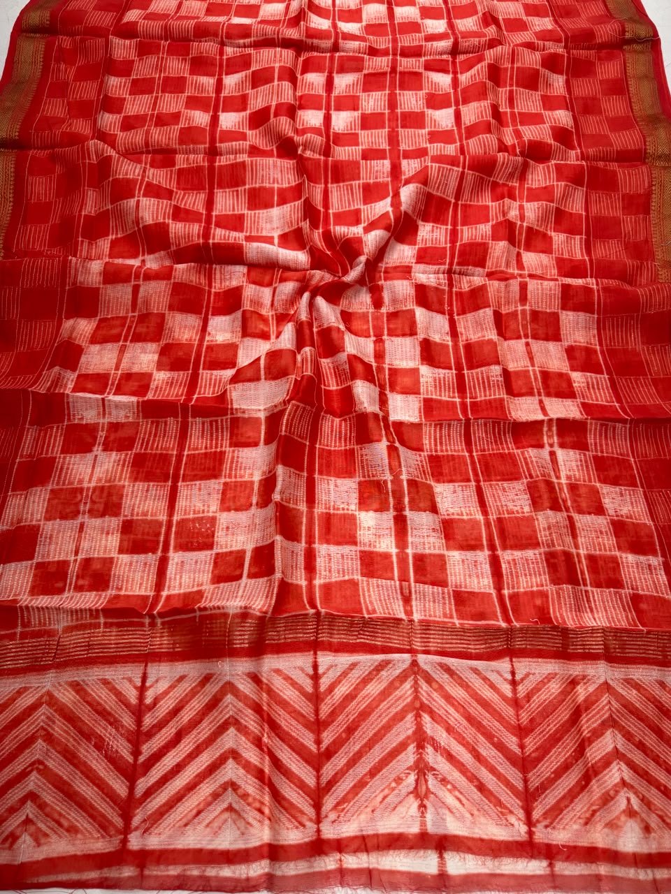 Detailed view of the vibrant orange handloom Maheshwari silk dupatta, featuring intricate block prints, shibori resist patterns, and the elegant handloom woven golden Zari border.