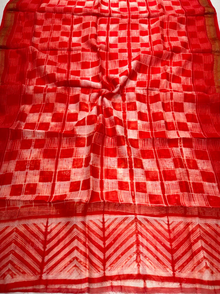 Detailed view of the vibrant orange handloom Maheshwari silk dupatta, featuring intricate block prints, shibori resist patterns, and the elegant handloom woven golden Zari border.
