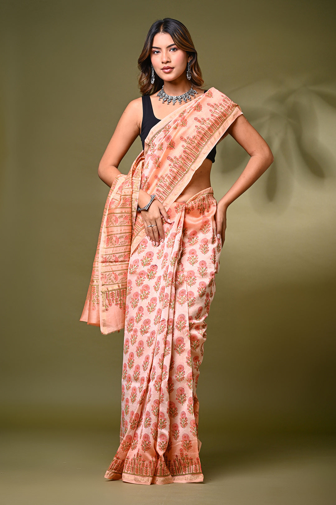An authentic pastel peach Chanderi silk saree showcasing a sheer, lightweight texture and fine Rajasthani hand block printed buti motifs.