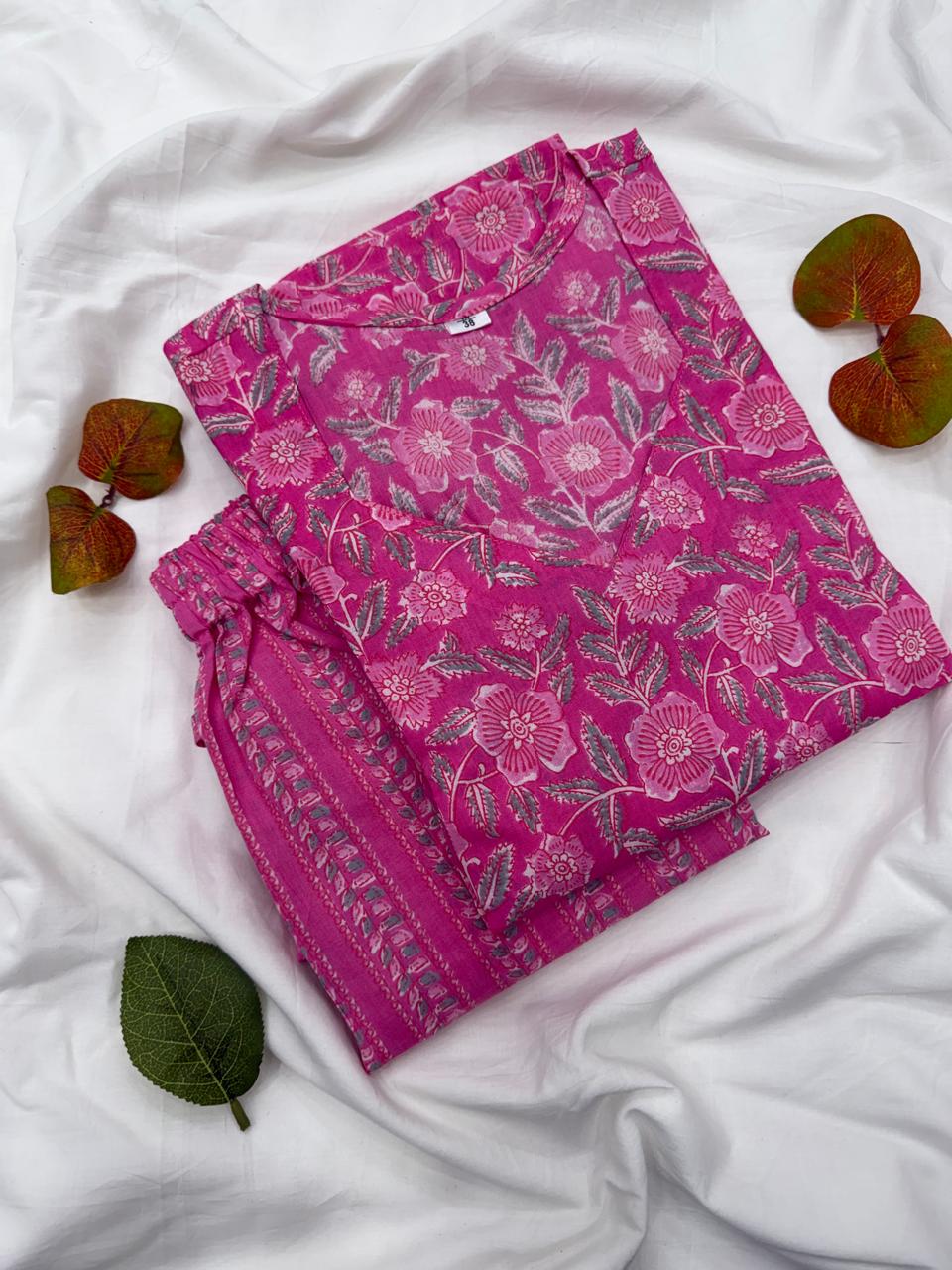 A combined close-up shot showing both the pink floral screen print kurta fabric and the matching printed pants layout together.