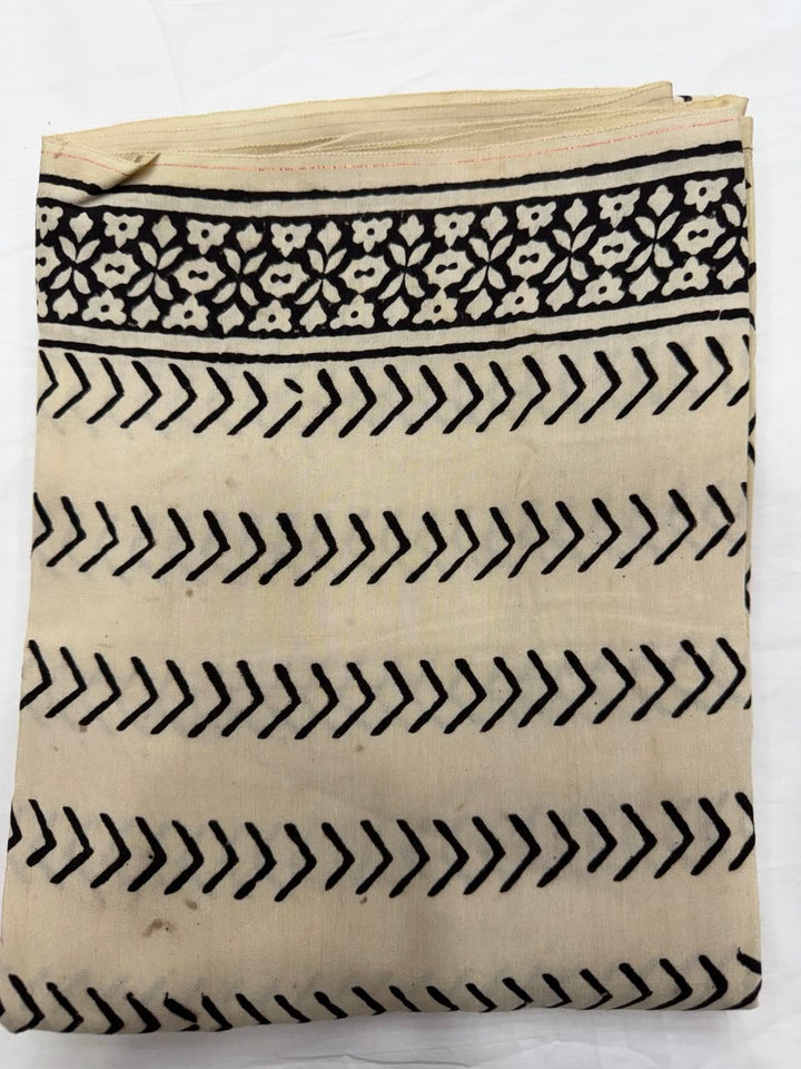 Premium quality unstitched Santoon silk bottom fabric in a solid cream color with a delicate black chevron pattern, neatly rolled for the peach Bagru print suit set.
