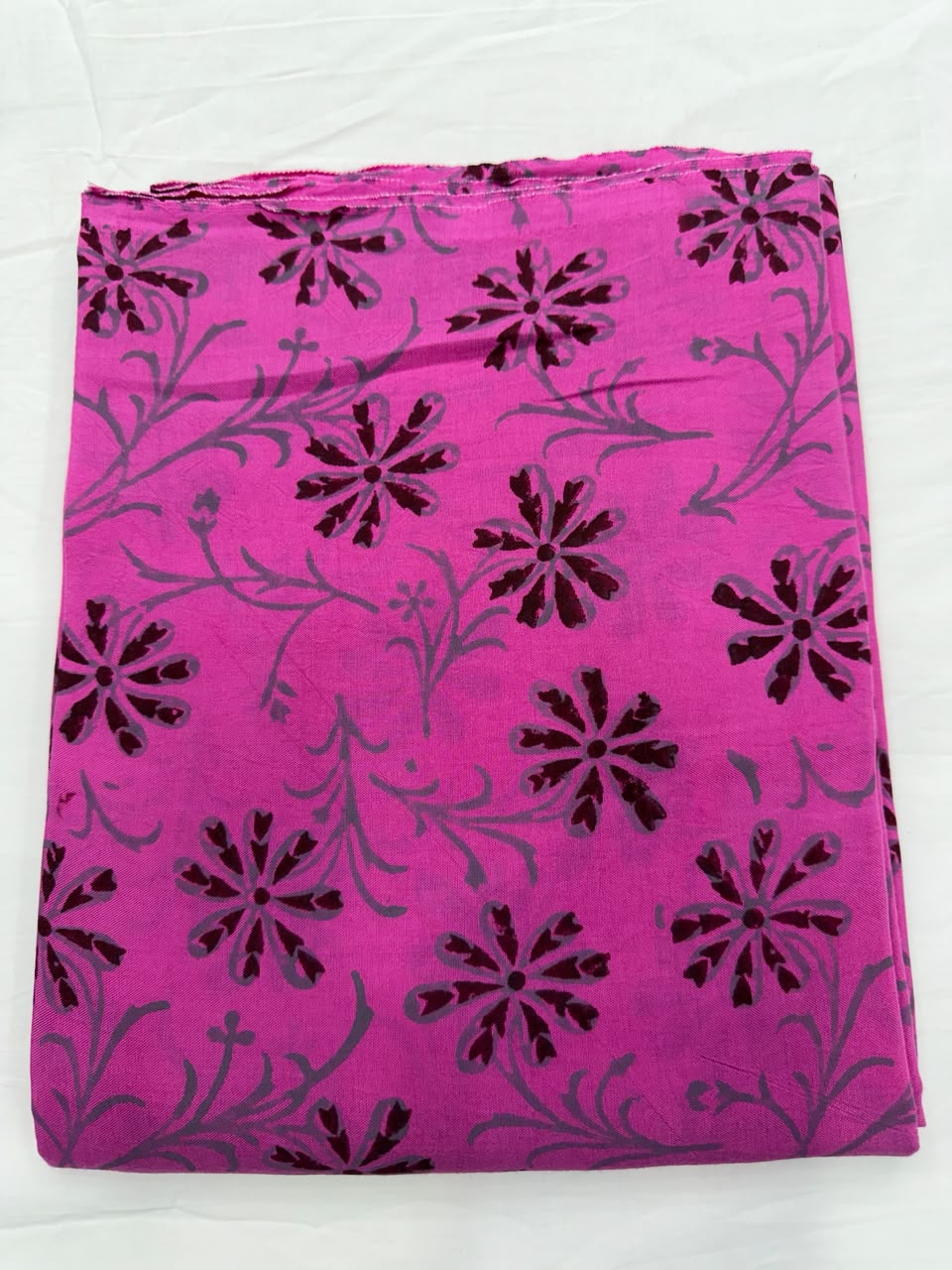 Premium quality unstitched Santoon silk bottom fabric in bright gulabi pink with contrasting black block prints, neatly rolled for the Maheshwari silk suit set.