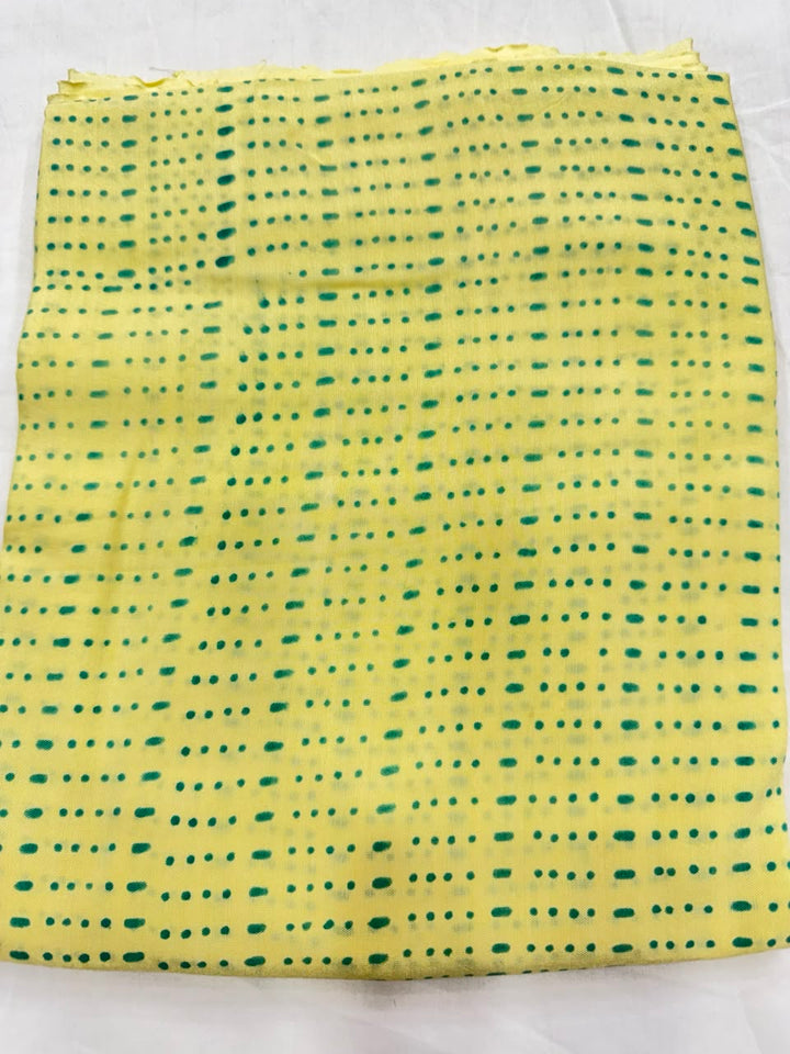Premium quality unstitched Santoon silk bottom fabric in a contrasting green color with an elegant block print pattern, neatly folded for the bright yellow Maheshwari silk suit set.