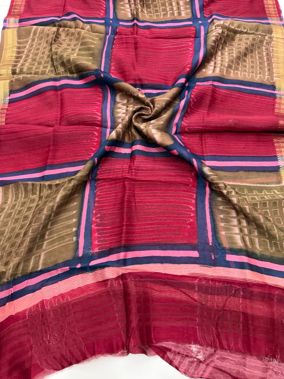 Detailed view of the red handloom Maheshwari silk dupatta, highlighting the unique batik wax-resist textures, patterns, and the elegant handloom woven golden Zari border.