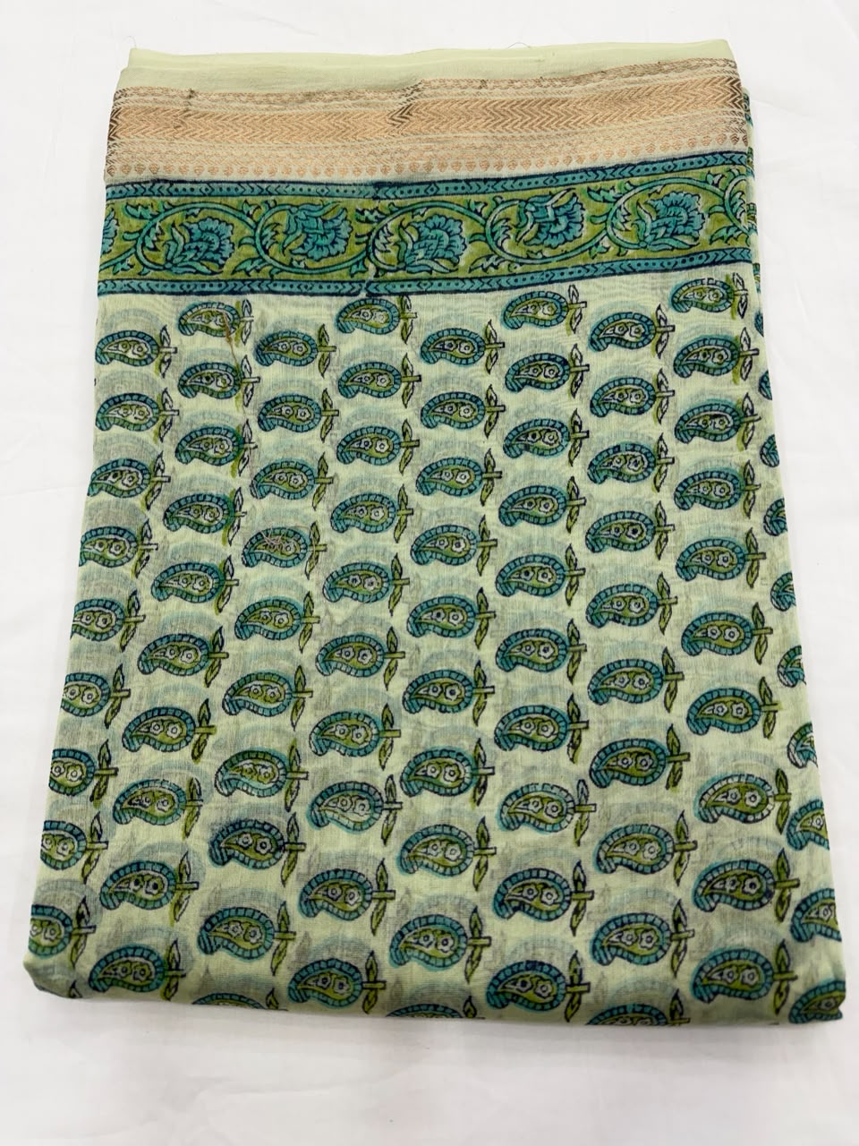 Close-up of the unstitched turquoise Maheshwari silk kurta fabric, featuring delicate, all-over traditional Sanganeri buti floral motifs hand-stamped by master block printers.