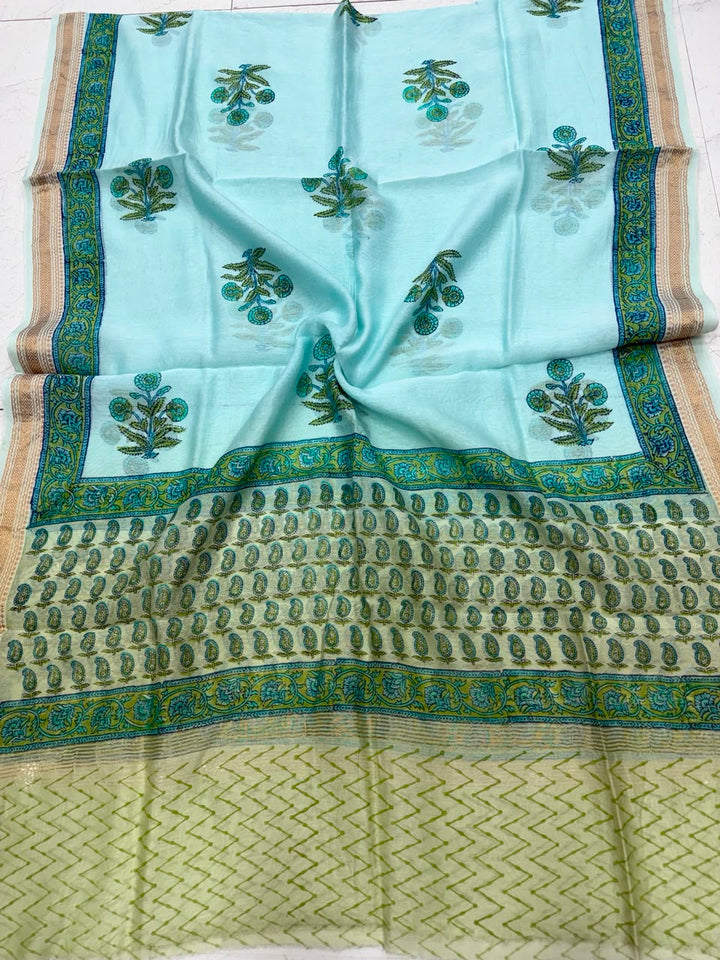 Detailed view of the turquoise handloom Maheshwari silk dupatta, highlighting the intricate Sanganeri traditional floral patterns, a light green border section, and a rich handloom woven golden Zari border.